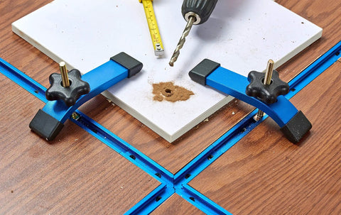 Two 24 Inch Aluminum T Track Set With Hold Down Clamps For Woodworking installed on a wooden table with a drill and ruler.
