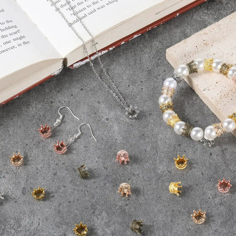 30 Pieces Mini Crown Charms Set for Crafters Mixed Color Vintage 3D Alloy King Crowns Beads on gray surface with jewelry