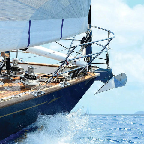 Aluminum winch handle on sailboat deck with chrome winches and rigging near the bow
