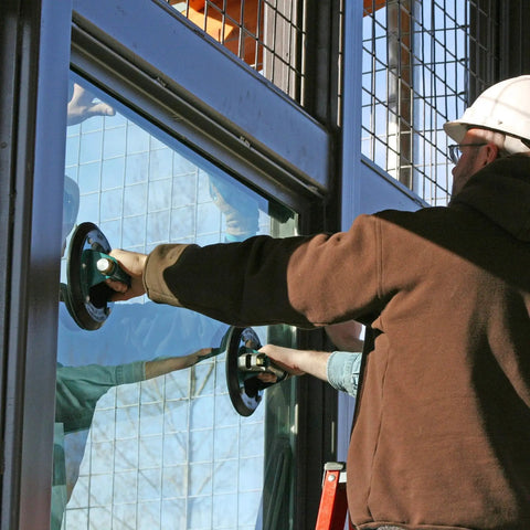 Worker using 10 Inch Concave Vacuum Cup With Metal Handle And Red Line Vacuum Loss Indicator to lift glass panel