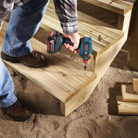 Person using Bosch impact driver with Impact Tough Insert Bits Set For Heavy Duty Drilling Boss Grade Bosch 10 Pack 1 Inch Phillips And Square Number Two With Xtended Torsion Zone Precision Tips Heat Treated High Visibility Laser Etched Sleeve on wooden steps