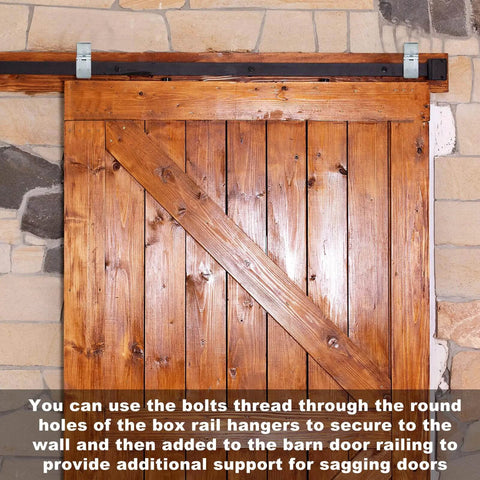 4 Pack Box Rail Hanger Brackets With Bolts For Exterior Barn Door Hardware installed on wooden barn door against stone wall.