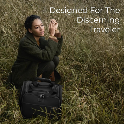 Person sitting in grass with Baseline Carry On Bag With Smooth Roll 2 Wheel Mobility Softside Luggage That Fits Overhead And Under Seats