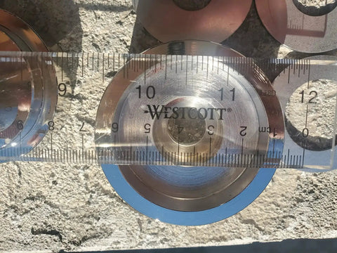 Close-up of a metal punch from the Coin Ring Puncher And Spacer Set For DIY Jewelry Making 5 Punch Tool with a ruler for scale