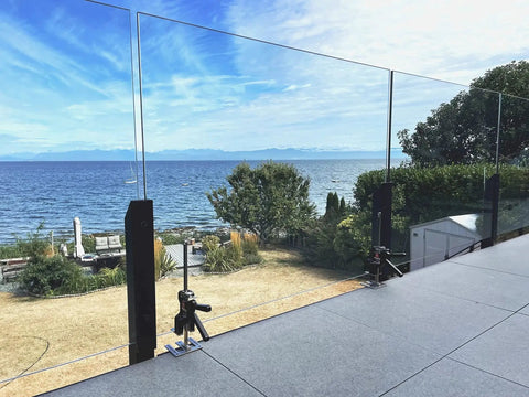 Original Handheld Jack and Clamp for One Hand Lifting Up to 330 Lbs shown in use on outdoor glass railing installation