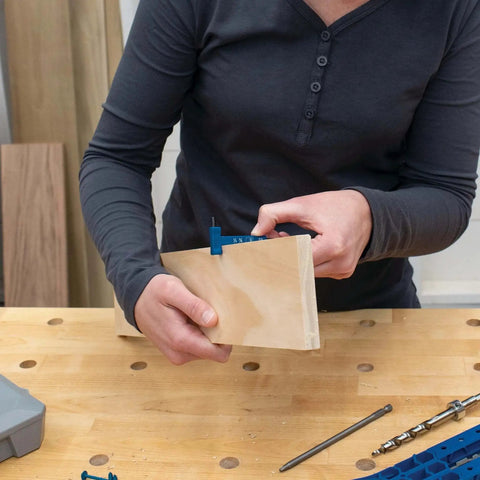 Person using Easy Set Pocket Hole Drill Bit with Stop Collar and Thickness Gauge for woodworking project by Kreg.