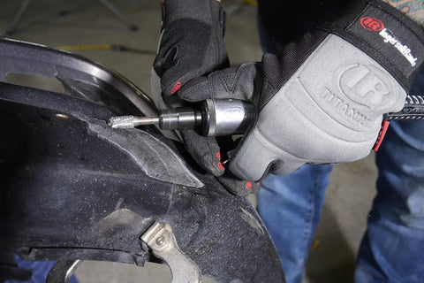 One Quarter Inch Air Die Grinder With Straight Head Design being used for grinding on a vehicle part