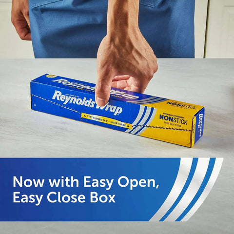 Person placing a hand on blue box of Nonstick Aluminum Foil Roll For Easy Cooking And Mess Free Cleanup Perfect For Covering Casseroles