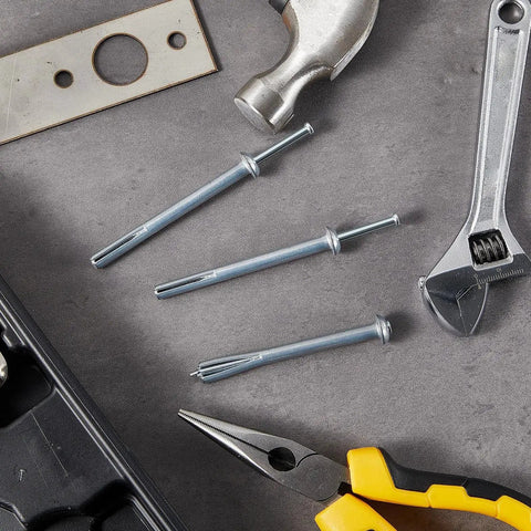 100 Pack One Quarter Inch By Three Inch Drive Nails For Anchor Hammer In Expansion Anchors Rustproof Zinc Plated Concrete Nails shown on a workbench with tools