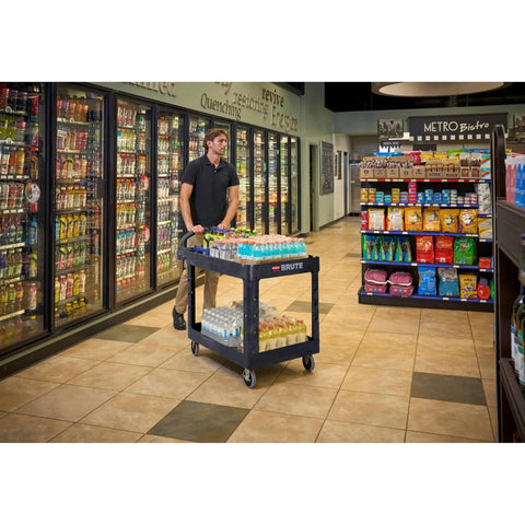 Employee using Two Shelf Foam Utility Cart With Lipped Shelves And Ergonomic Handle Black 500 Lb Capacity Durable Rolling Cart in store