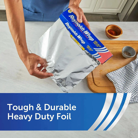 Person using Heavy Duty Aluminum Foil Roll Beefy Strength 12 Inch Wide 50 Square Feet With Secure Easy Open Tab in kitchen.