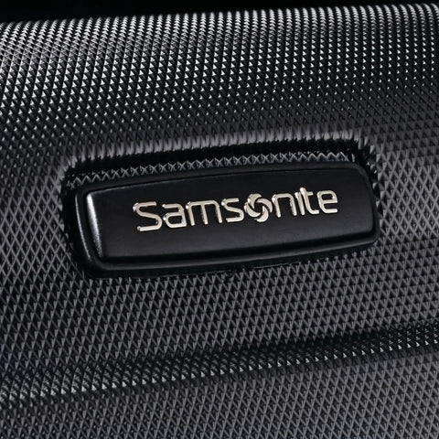 Close-up of Samsonite logo on black Expandable Hardside Carry On Luggage With Four Spinner Wheels For Easy Travel, 20 Inch Size, Lightweight And Durable