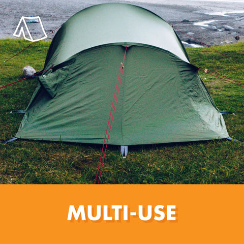 Green tent set up on grass with lake view, multi-use label in foreground
