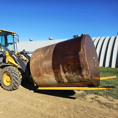 92 Inch Forklift Extensions For 4.5 Inch Wide Forks Heavy Duty Pair lifting large metal tank outdoors