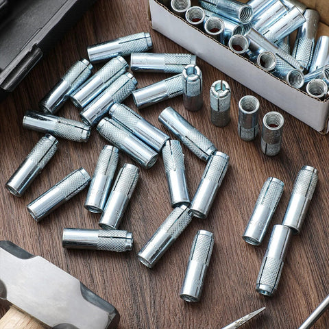 100 Pcs 3/8-16 Concrete Anchors Zinc Plated Carbon Steel Drop-In Anchors scattered on a wooden surface