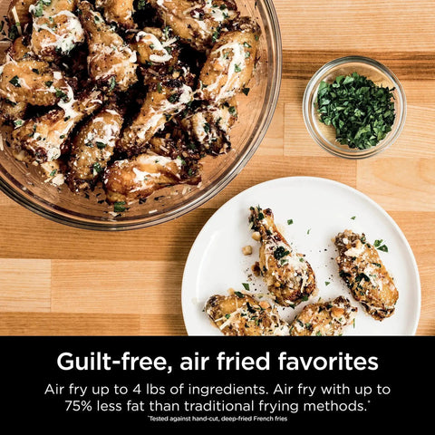 Chicken wings on a plate and in a bowl with herbs, air fried using Digital Air Fry Pro Countertop Oven With Extended Height And XL Capacity.