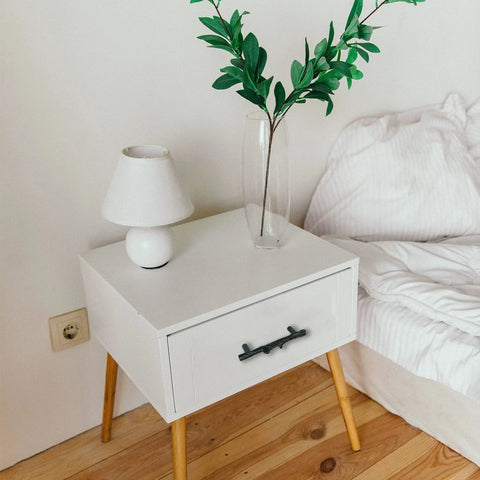 Nightstand with Six Piece Tree Branch Cabinet Handles Set In Black Twig Style installed on drawer by bed.