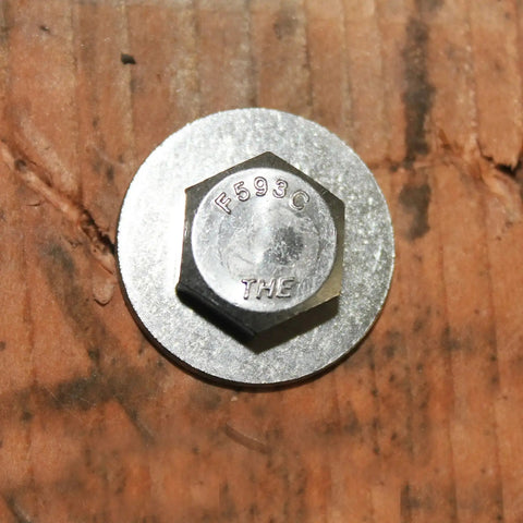 Close-up of Tough-As-Nails 3/8-16 x 5 stainless steel hex bolt head on wood surface, fully threaded, corrosion-resistant