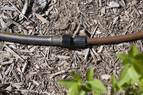 Habitech 3-pack drip irrigation hose adapters, black plastic fittings joining 1/2 in tubing to a garden hose on mulch