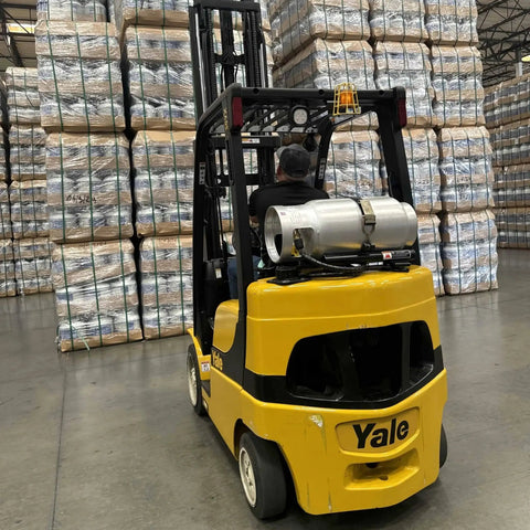 Aluminum 33.5 Lb Forklift Propane Tank With Integrated Gauge Durable Lightweight installed on a yellow forklift in a warehouse
