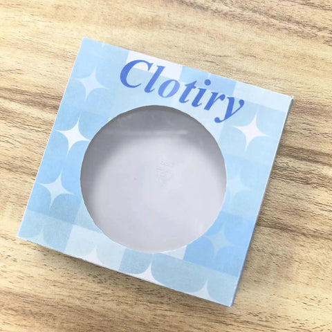 Blue Clotiry cardboard box with round window on wooden surface
