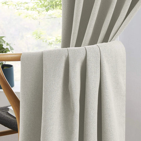 Close-up of 100 Percent Blackout Linen Curtains in Greyish Beige, 50x126 Inches, Two Panels draped over a chair in a living room.
