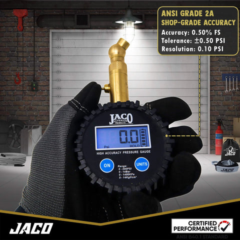 JACO Elite digital tire pressure gauge with brass nozzle, blue LCD display, held by gloved hand.