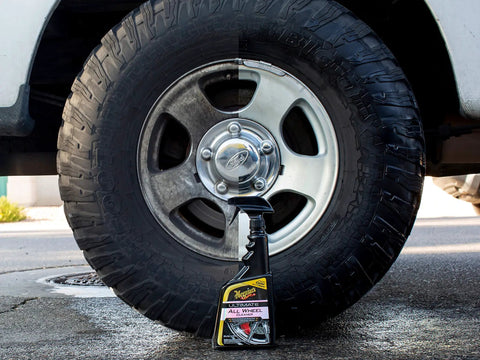 Fast Acting All Wheel Cleaner That Destroys Brake Dust, Turns Purple While Dissolving Grime, Safe For All Wheel Finishes And Brakes, Acid Free And PH Balanced Meguiars in front of a truck wheel.