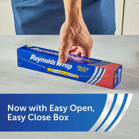 Person holding Heavy Duty Aluminum Foil Roll Beefy Strength 12 Inch Wide 50 Square Feet With Secure Easy Open Tab package on table