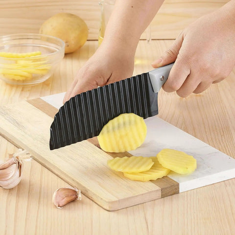 Person using Crinkle Cut Knife For Veggies And Fries With Stainless Steel Wave Blade And Ergonomic Handle VITUER to cut potatoes on a board.