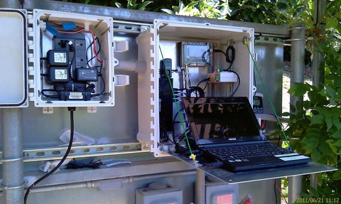 Rugged Polycarbonate Enclosure With Hinged Locking Opaque Cover, 24 x 24 x 10 Inches, used with electronic equipment outdoors.