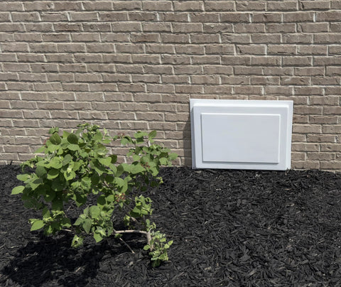 Crawl space access door, white, 24 in high by 36 in wide, resting against brick foundation wall.