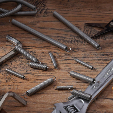 PPFEITOU 12pcs stainless steel extension springs with hook ends, 0.03 in dia x 0.4 in coil, 6.5 in long on wood bench