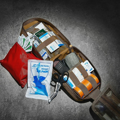 Military Grade IFAK Trauma Kit With CAT Gen 7 Tourniquet Israeli Bandage, organized in open MOLLE bag on concrete surface