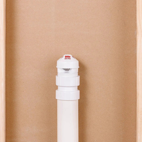 Sure Vent Air Admittance Valve 1 1/2 To 2 In DWV With White PVC Sch 40 Adapter installed on a vertical pipe in a wall frame.