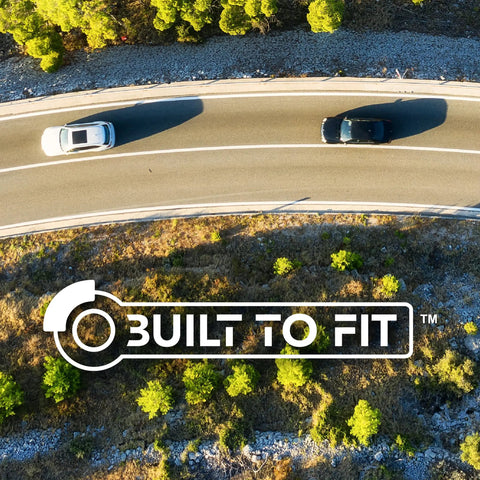 Automotive parts image; overhead view of curved highway with white and black cars and a Built To Fit watermark.