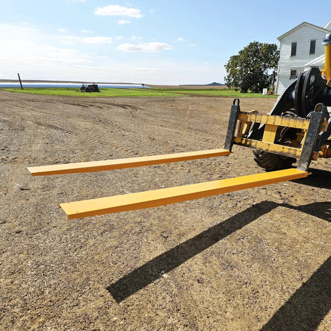 92 Inch Forklift Extensions For 4.5 Inch Wide Forks Heavy Duty Pair installed in use on a construction site