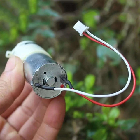 Close-up of Ultra Compact Self Priming Diaphragm Water Pump with DC 6V to 12V, 370 Micro Motor, held showing wiring detail.
