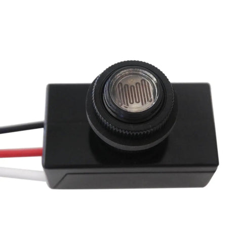 Close-up of Dusk To Dawn Outdoor Light Switch Controller With Photoelectric Sensor, compact black design, hard wired for outdoor lamps.