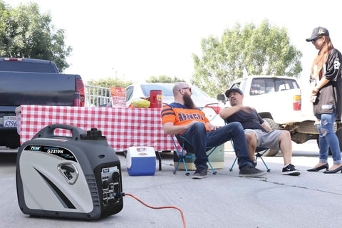 Quiet 2300W Portable Gas Powered Inverter Generator With USB Outlet beside tailgating setup with people chatting