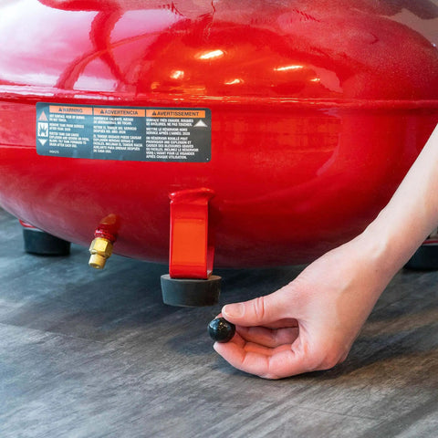 Person installing 0.75 inch diameter hemisphere rubber bumpers with adhesive non skid feet under red machinery for noise dampening.