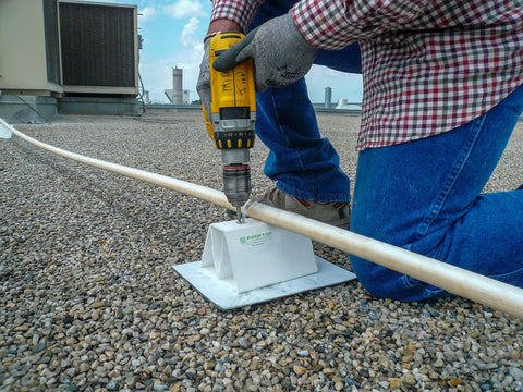 Person installing the Adjustable 36 Inch PVC Rooftop Pipe Support that Can Be Cut To Desired Length For Roof Conduit Gas Lines Condensate Piping And HVAC Units.