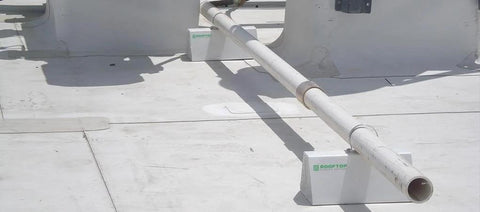 Adjustable 36 Inch PVC Rooftop Pipe Support That Can Be Cut To Desired Length For Roof Conduit Gas Lines Condensate Piping And HVAC Units, installed on a flat roof with piping.