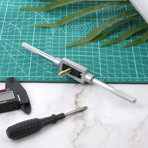 Adjustable Tap Wrench Handle M3 To M12 With 1/16 To 1/2 Inch Capacity For Pros And DIYers on a green cutting mat with tools