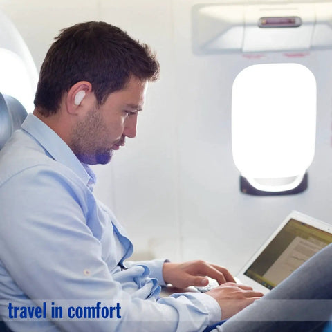 Man wearing Pillow Soft Moldable Silicone Ear Plugs For Sleeping And Travel on airplane, focusing on laptop