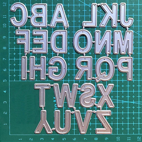 26 Capital Alphabet Dies Set For Metal Cutting, Card Making, Scrapbooking And DIY Embossing Projects on green grid