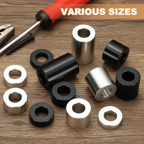 Assorted black and silver aluminum spacers on wooden table, ideal for electronics and mechanical projects, varying sizes visible.