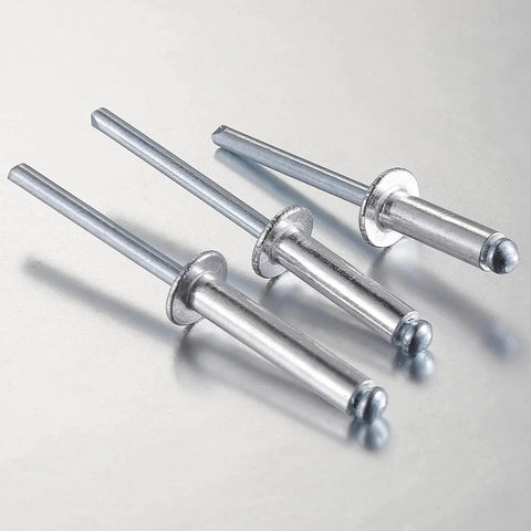 Close-up of three 250 Pack Aluminum Blind Rivets Three Sixteenths By One Half Inch With Aluminum Grip And Steel Mandrel on metal surface.
