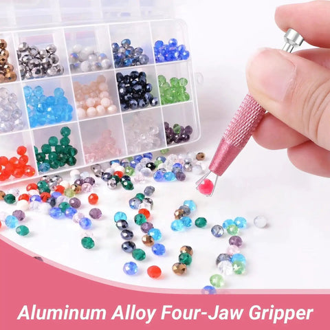 Aluminum alloy four-jaw gripper holding red bead near sorted gemstone collection in box