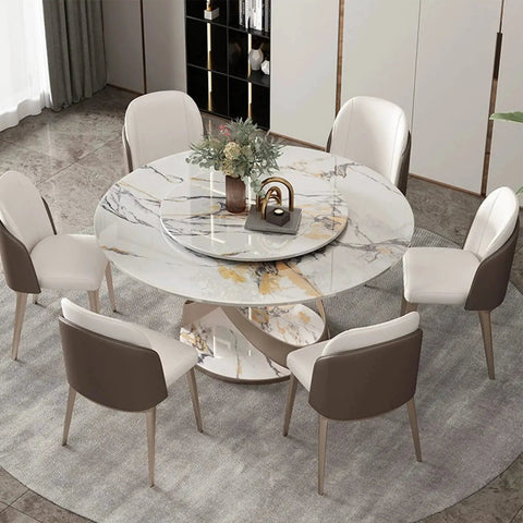 Dining table with marble top featuring Lazy Susan centerpiece, surrounded by white and brown chairs on a gray rug in modern room.